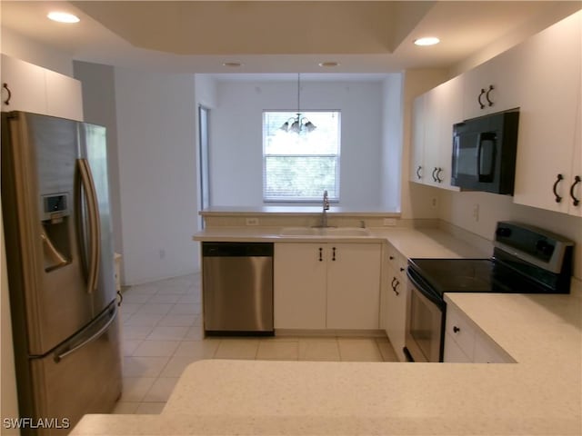 kitchen with stainless steel appliances, a sink, recessed lighting, light countertops, and hanging light fixtures