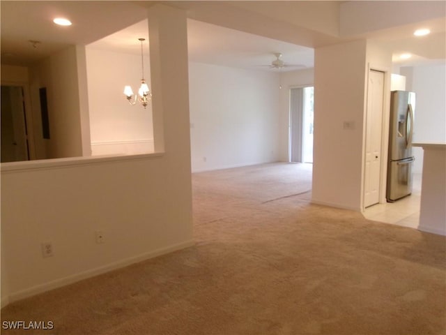 empty room with light carpet, a chandelier, ceiling fan, recessed lighting, and baseboards