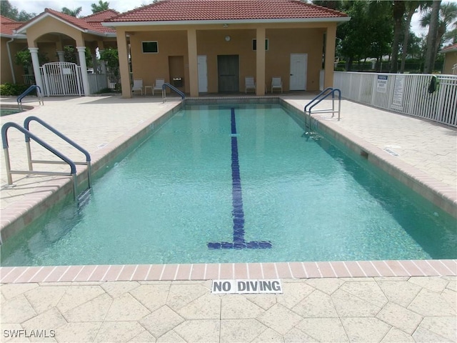 community pool featuring a patio area and fence