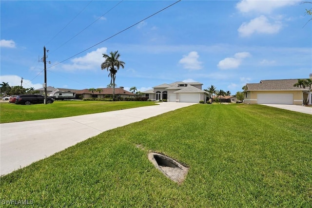 view of front of house with concrete driveway, a garage, a residential view, and a front yard