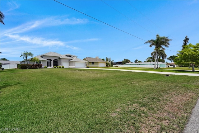 view of yard with concrete driveway and a garage