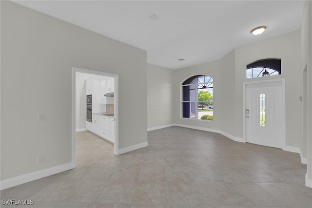 entryway with baseboards and light tile patterned floors