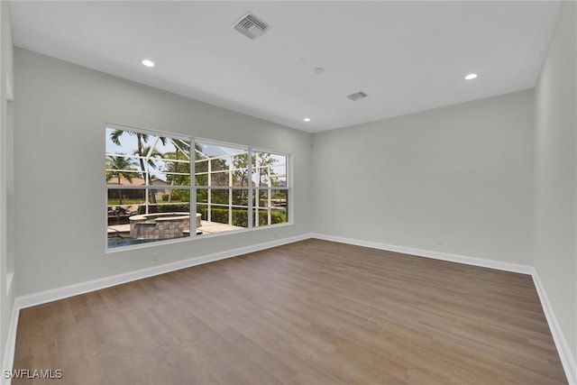 unfurnished room with baseboards, recessed lighting, visible vents, and wood finished floors