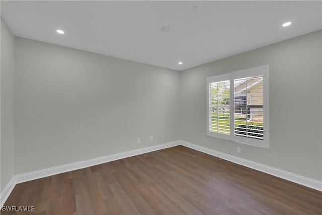unfurnished room with baseboards, recessed lighting, and dark wood-style floors
