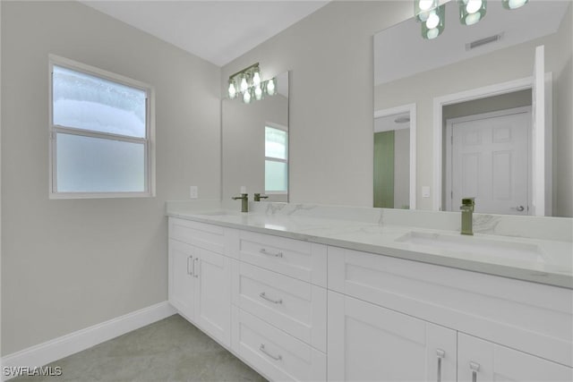 bathroom with double vanity, visible vents, baseboards, and a sink