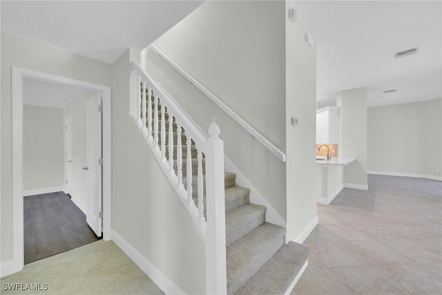 staircase featuring visible vents and baseboards