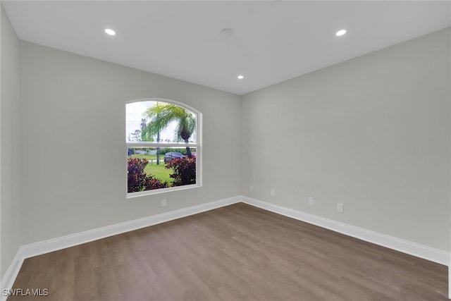 empty room with baseboards, dark wood-style floors, and recessed lighting