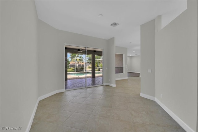 spare room with baseboards, a ceiling fan, and light tile patterned floors