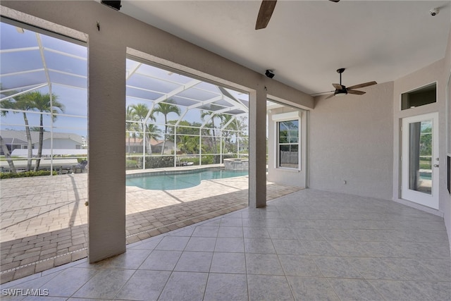 view of pool with glass enclosure, a patio, ceiling fan, and a pool with connected hot tub