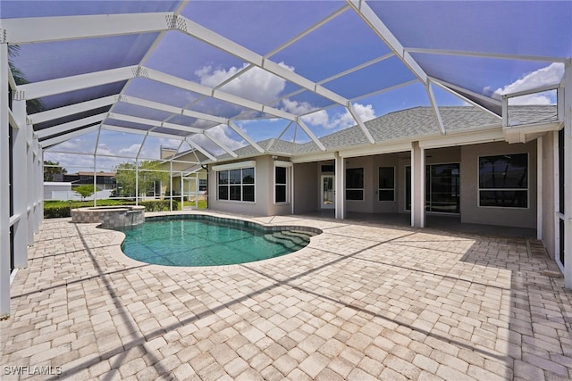 view of swimming pool with a patio, a pool with connected hot tub, and a lanai