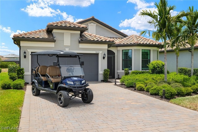 19652 Deming Ln, Estero, FL 33928 - mediterranean / spanish home with decorative driveway, a garage, stucco siding, and a tile roof