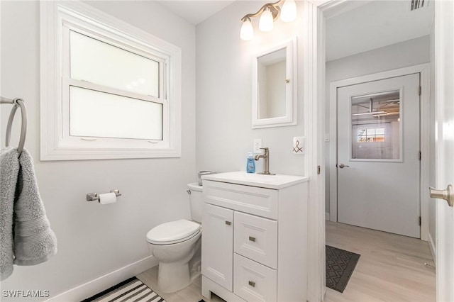 420 Donora Blvd, Fort Myers Beach, FL 33931 - half bathroom featuring toilet, wood finished floors, vanity, and baseboards