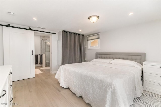 420 Donora Blvd, Fort Myers Beach, FL 33931 - bedroom with light wood-type flooring, a barn door, recessed lighting, and ensuite bath