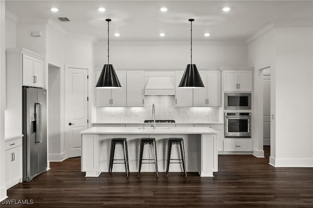 19570 Panther Island Blvd, Estero, FL 33928 - kitchen with stainless steel appliances, custom exhaust hood, light countertops, a kitchen island with sink, and ornamental molding