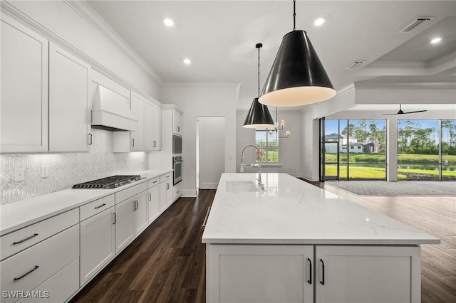 19570 Panther Island Blvd, Estero, FL 33928 - kitchen with a sink, custom range hood, stainless steel appliances, ornamental molding, and a center island with sink