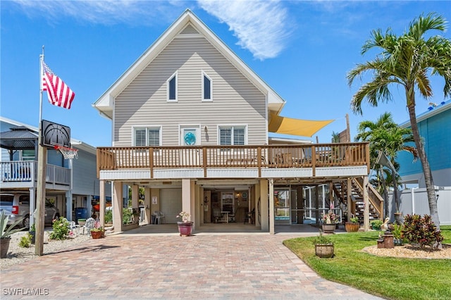exterior space with stairs, a deck, decorative driveway, and a carport