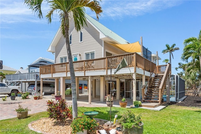 rear view of property with a lawn, stairway, a wooden deck, and a carport