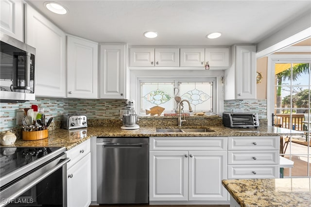 kitchen with stainless steel appliances, white cabinets, a toaster, and a sink