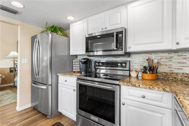 kitchen featuring light wood-style floors, white cabinetry, visible vents, backsplash, and appliances with stainless steel finishes