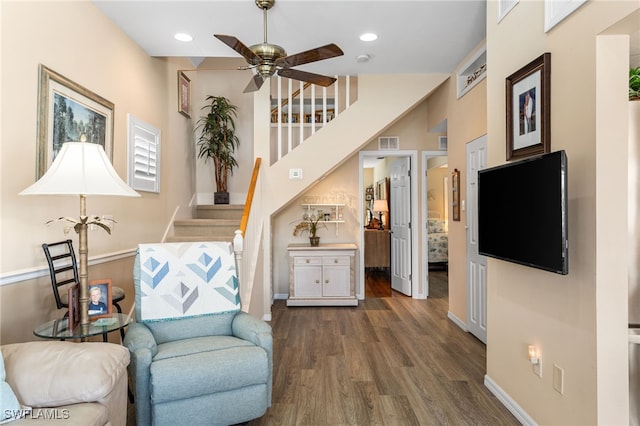 sitting room featuring stairs, visible vents, dark wood-style floors, a ceiling fan, and baseboards