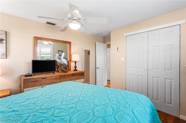 bedroom featuring ceiling fan, a closet, visible vents, and wood finished floors
