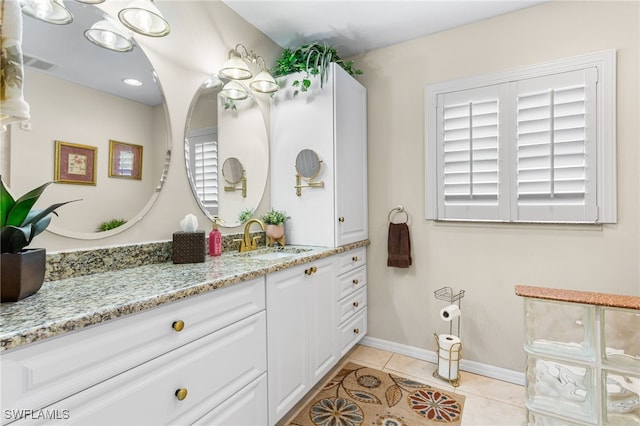bathroom featuring vanity, baseboards, visible vents, and tile patterned flooring