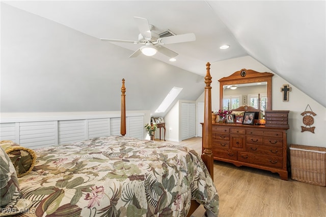 bedroom with vaulted ceiling with skylight, wood finished floors, visible vents, recessed lighting, and a ceiling fan