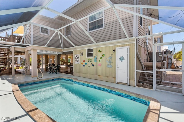 back of property with a patio and an outdoor pool