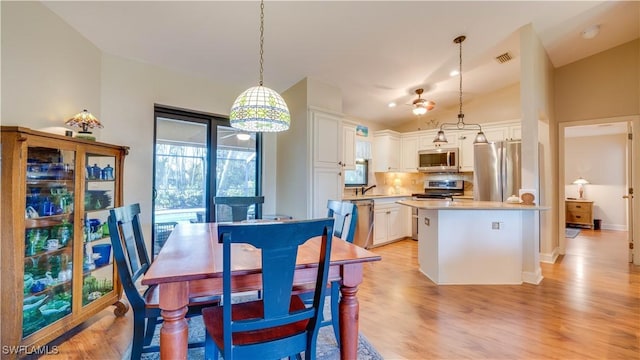 1017 SW 37th Ln, Cape Coral, FL 33914 - dining room with light wood finished floors, lofted ceiling, a ceiling fan, and visible vents