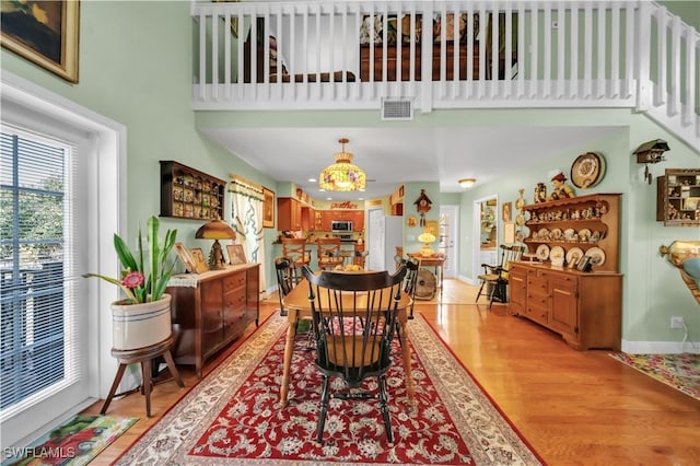 18511 Slater Rd, North Fort Myers, FL 33917 - dining area featuring light wood-style flooring, baseboards, and a high ceiling