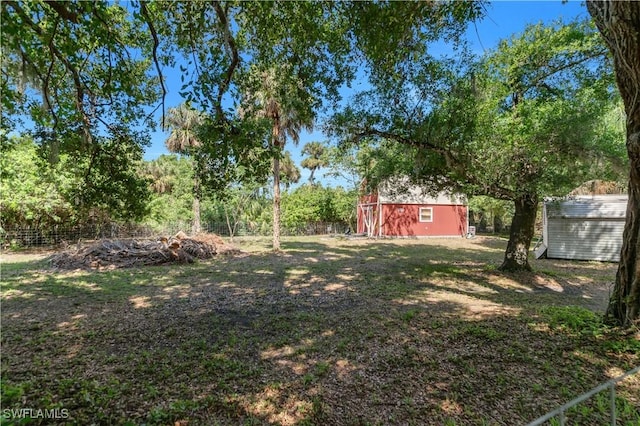 18511 Slater Rd, North Fort Myers, FL 33917 - view of yard featuring a storage shed, an outbuilding, and fence