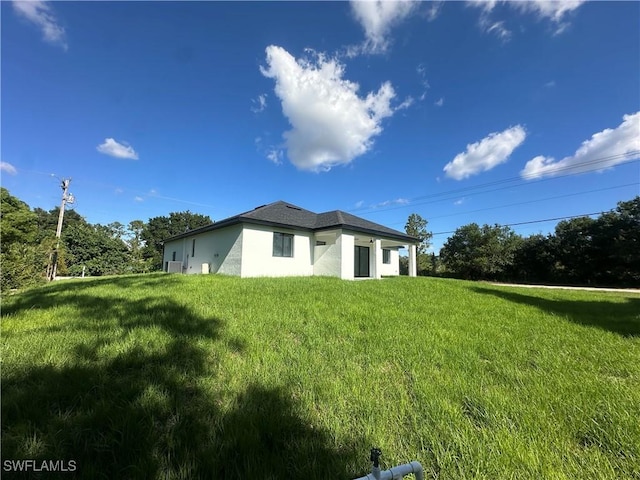 178 Mcarthur Blvd, Lehigh Acres, FL 33974 - rear view of property with a yard and stucco siding