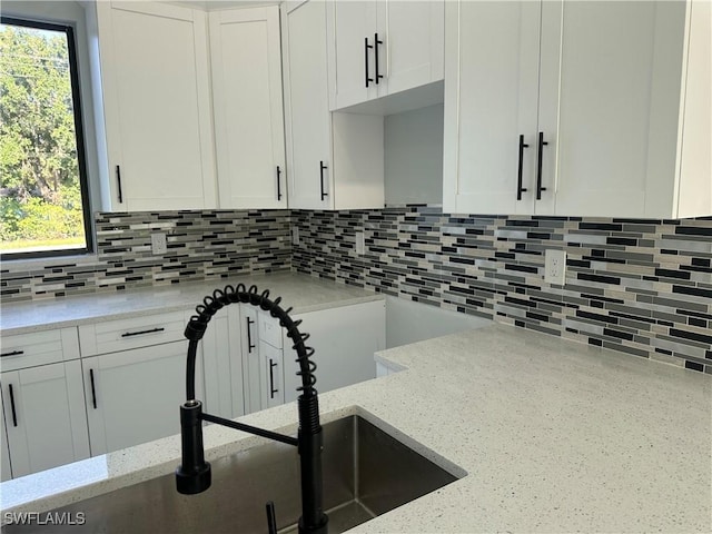 178 Mcarthur Blvd, Lehigh Acres, FL 33974 - kitchen featuring tasteful backsplash, light stone countertops, and white cabinets