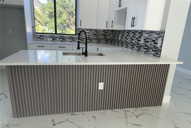 178 Mcarthur Blvd, Lehigh Acres, FL 33974 - kitchen with marble tiled flooring, decorative backsplash, and white cabinets