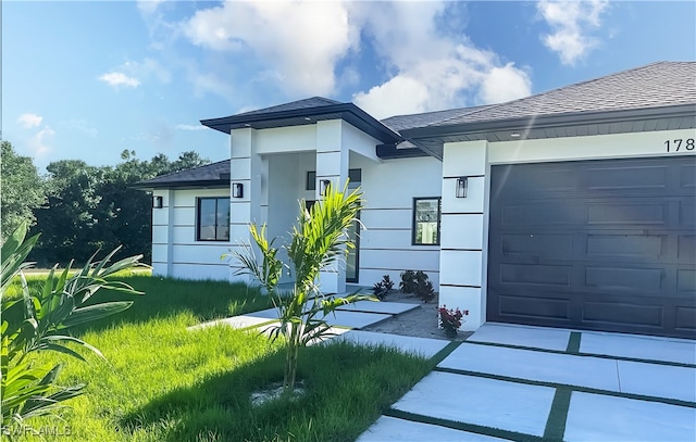 178 Mcarthur Blvd, Lehigh Acres, FL 33974 - view of front of house with stucco siding, an attached garage, and a shingled roof