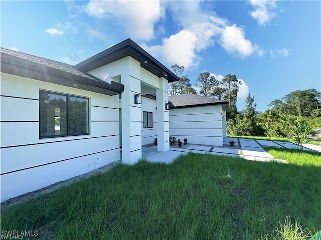 178 Mcarthur Blvd, Lehigh Acres, FL 33974 - view of home's exterior featuring a lawn