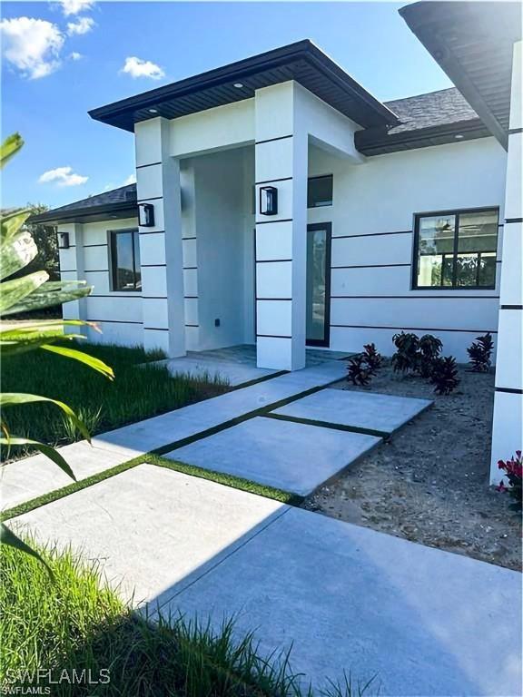 178 Mcarthur Blvd, Lehigh Acres, FL 33974 - doorway to property featuring stucco siding