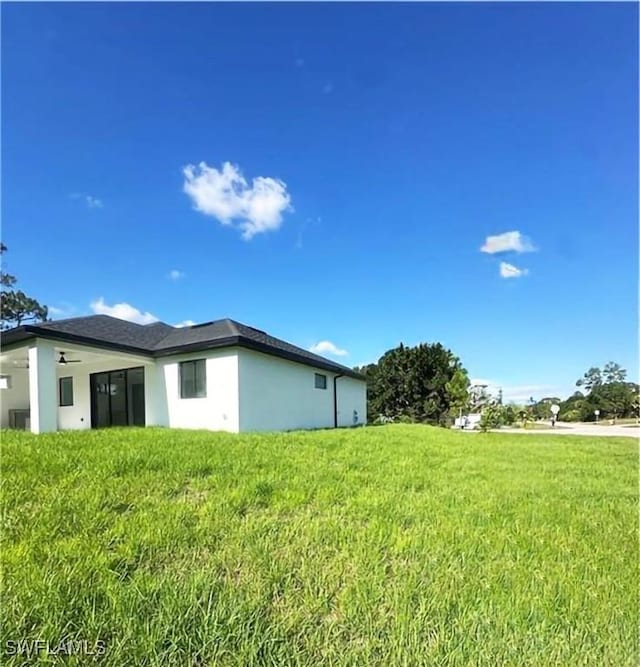 178 Mcarthur Blvd, Lehigh Acres, FL 33974 - view of property exterior featuring a lawn and stucco siding