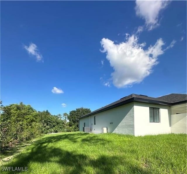 178 Mcarthur Blvd, Lehigh Acres, FL 33974 - view of home's exterior featuring stucco siding and a yard
