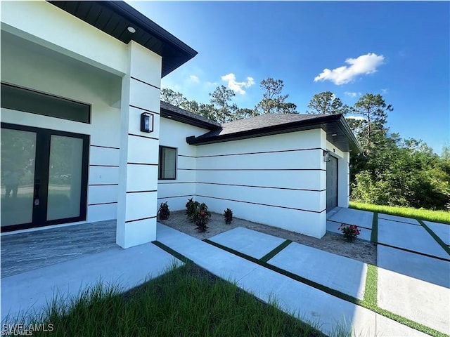 178 Mcarthur Blvd, Lehigh Acres, FL 33974 - view of side of property with french doors and stucco siding