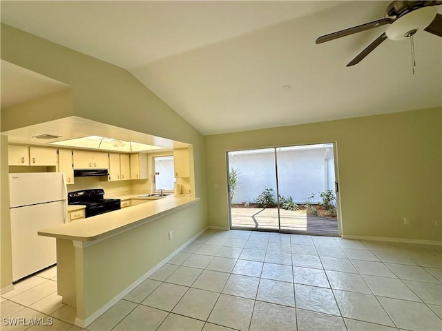 kitchen featuring freestanding refrigerator, under cabinet range hood, light tile patterned floors, black / electric stove, and vaulted ceiling