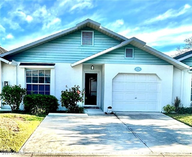 view of front of property featuring an attached garage, driveway, and stucco siding