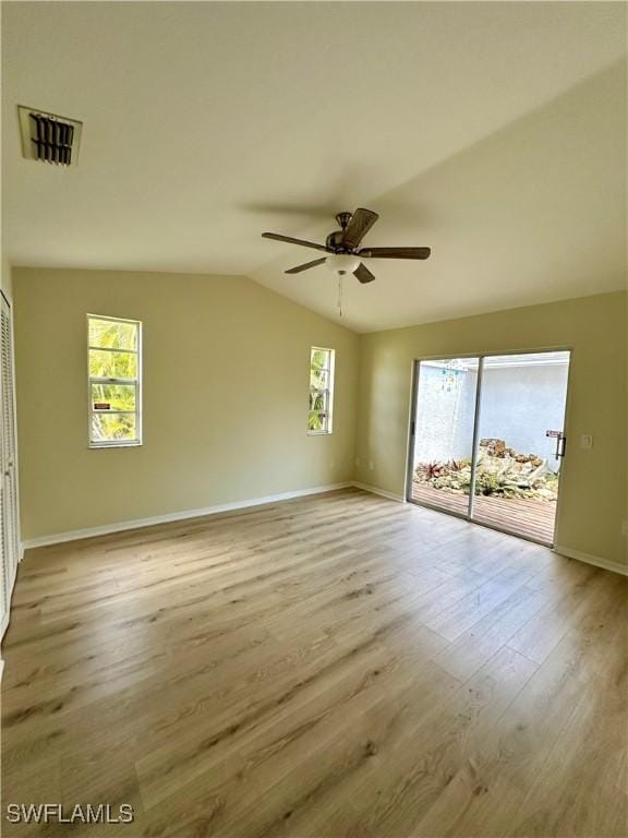 unfurnished room featuring a ceiling fan, visible vents, wood finished floors, baseboards, and lofted ceiling