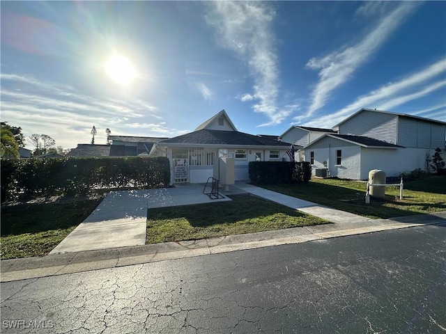 bungalow-style home featuring central AC unit and a front lawn