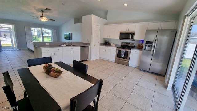2847 SW 26th Pl, Cape Coral, FL 33914 - kitchen with light tile patterned flooring, appliances with stainless steel finishes, a peninsula, a ceiling fan, and lofted ceiling