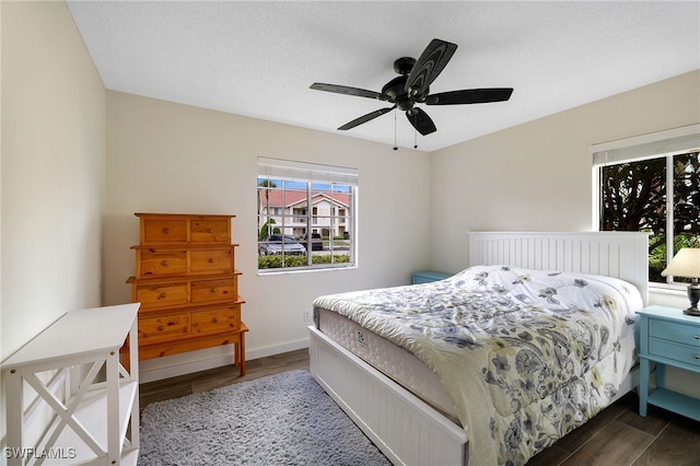 bedroom featuring wood finished floors, a ceiling fan, and baseboards