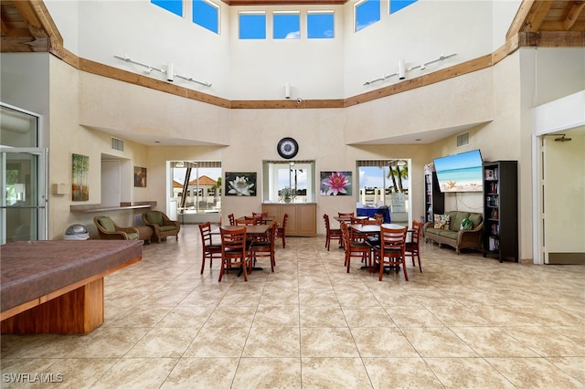 dining area with a high ceiling and light tile patterned floors