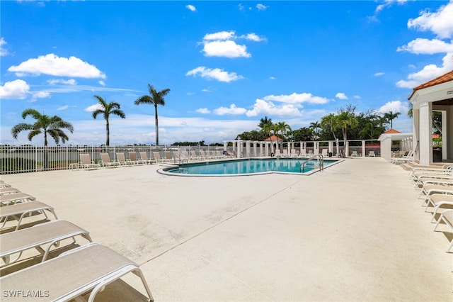 community pool with fence and a patio area