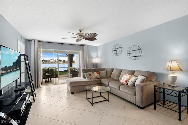 living area with ceiling fan, light tile patterned floors, and a water view