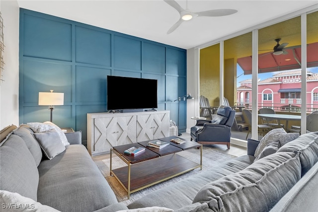 living area featuring ceiling fan and a decorative wall